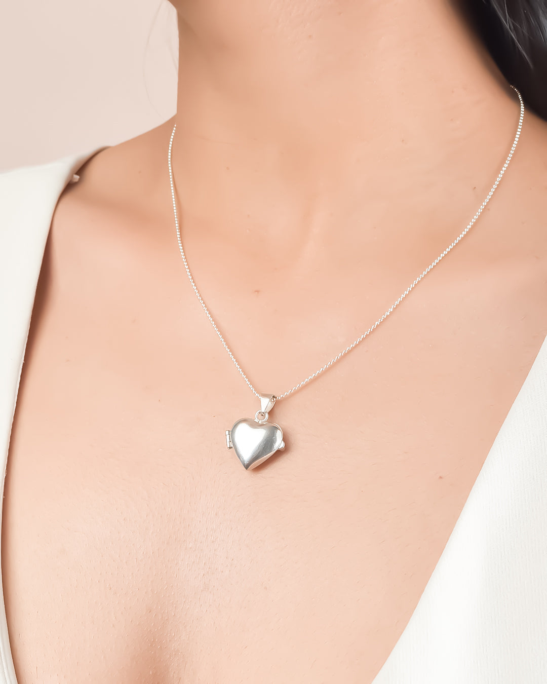 Collar relicario de plata en forma de corazón liso donde se pueden colocar fotos