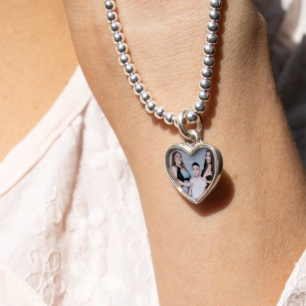 Pulsera de plata con portafoto. Pulsera de bolas plateadas con dije de corazón para colocar foto