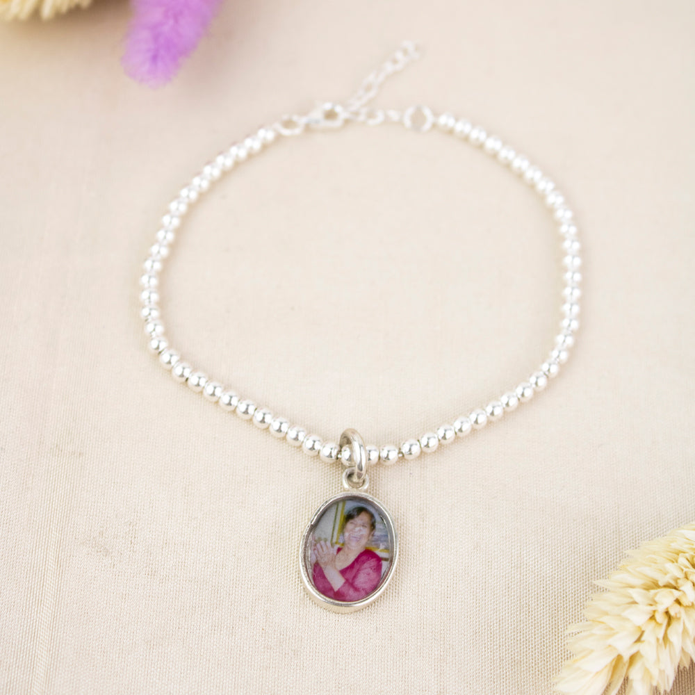 Pulsera de plata con portafoto. Pulsera de bolas plateadas con dije de oval para colocar foto
