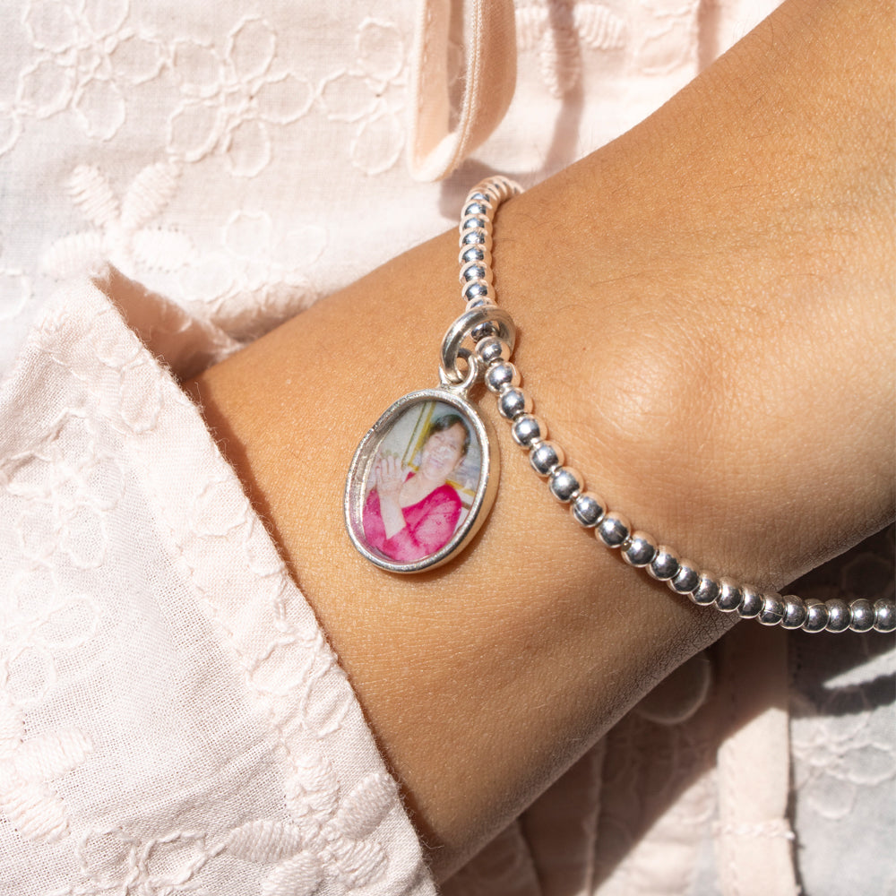 Pulsera de plata con portafoto. Pulsera de bolas plateadas con dije de oval para colocar foto