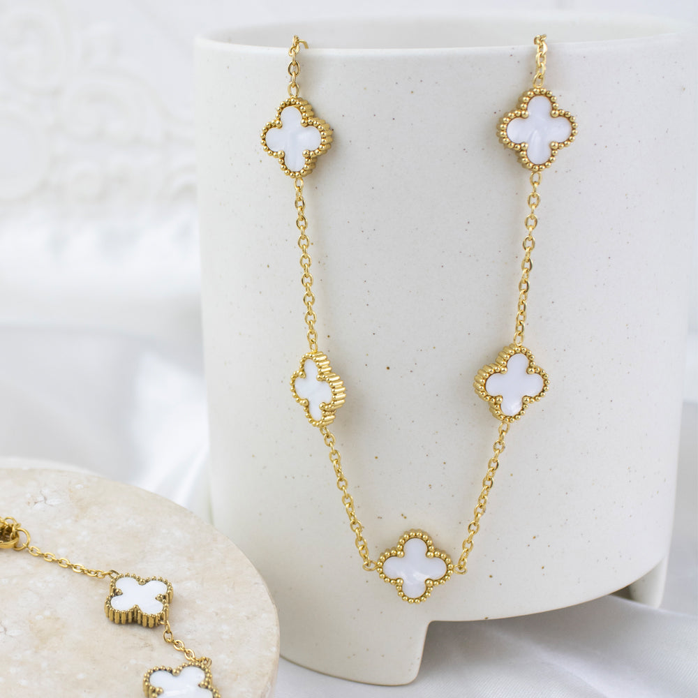 Collar de tréboles blancos o nacarados en tendencia en tono dorado
